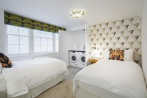 a bedroom with two beds and a window at Sea-facing Art Deco Apartment in Brighton & Hove