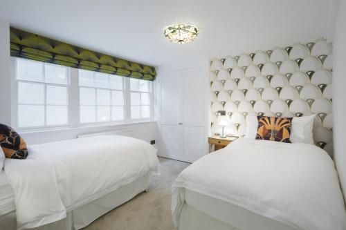 a bedroom with two beds and a window at Sea-facing Art Deco Apartment in Brighton & Hove