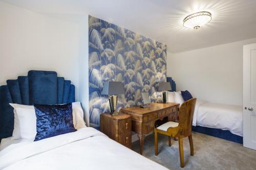 a bedroom with a bed and a desk with a chair at Sea-facing Art Deco Apartment in Brighton & Hove