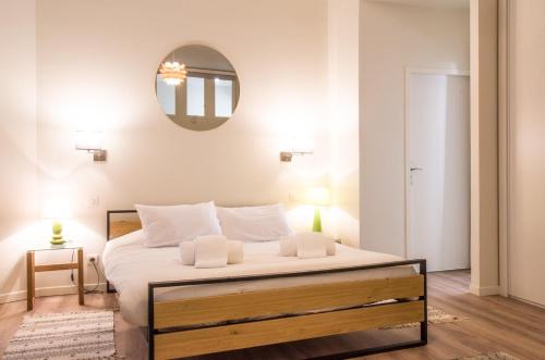 1 dormitorio con 1 cama grande y espejo en la pared en Symphonie by Cocoonr, en Toulouse