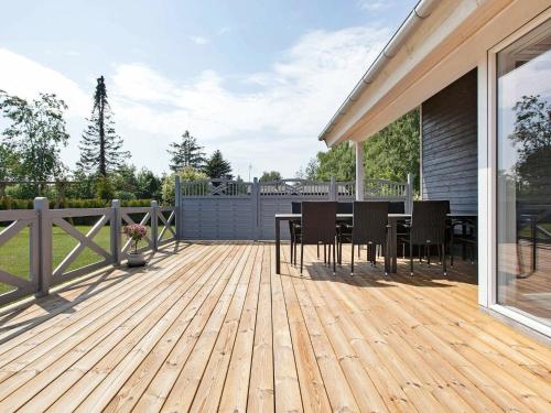 een houten terras met een tafel en stoelen erop bij 8 person holiday home in V ggerl se in Bøtø By