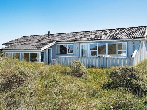 een blauw huis bovenop een heuvel bij 12 person holiday home in Hj rring in Lønstrup