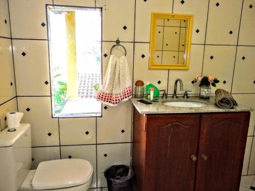 マイリポランにあるPousada Pitorescaのバスルーム(トイレ、洗面台付)、窓が備わります。