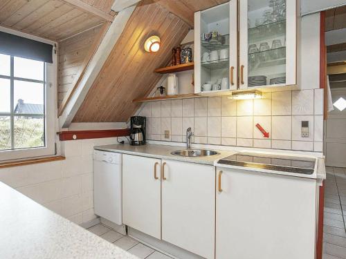 uma cozinha com armários brancos e um lavatório em 6 person holiday home in Ringk bing em Klegod