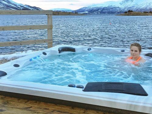 een jongen in een jacuzzi in het water bij 11 person holiday home in Gullesfjord in Flesnes