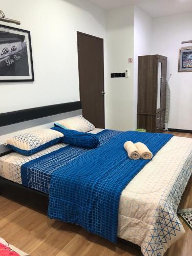 a bedroom with a bed with two towels on it at Home Suhaila in Kota Kinabalu