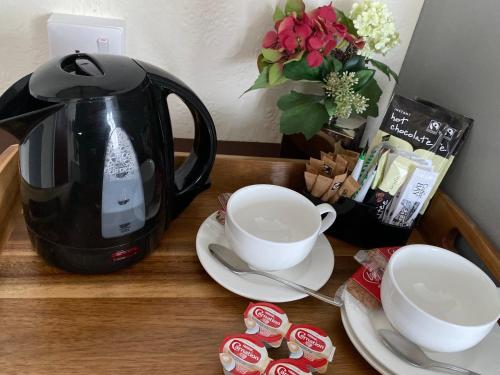 a table with a coffee pot and cups on it at Black Lion in Surbiton