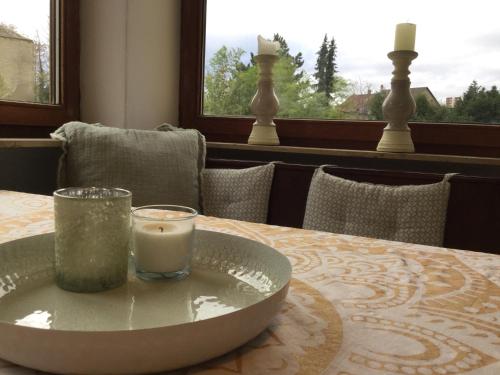 a candle on a plate on a table with a window at Ruhige Ferienwohnung Beletage in Neuwied