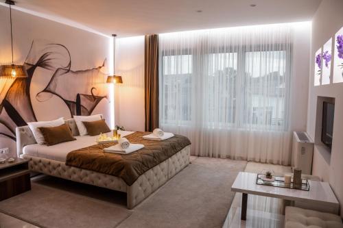a hotel room with a large bed and a television at Princ Apartment in Niš
