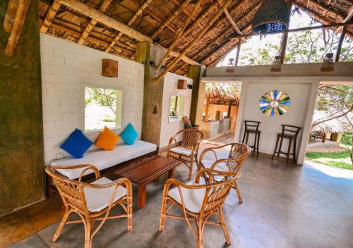 a living room with a table and chairs and a couch at Back of beyond - Wellness Retreat in Tangalle