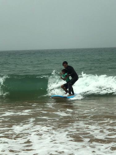 a man riding a wave on a surfboard in the ocean at Villa Jardin De l'Ocean in Aourir
