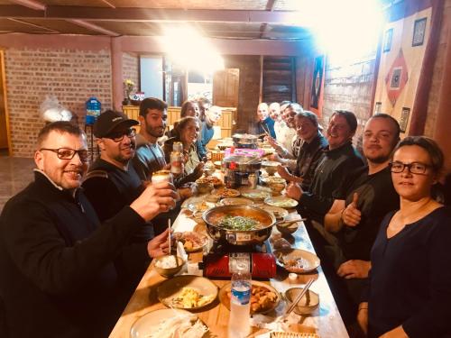 a group of people sitting around a table eating food at Meo Vac Cosy Hostel in Mèo Vạc