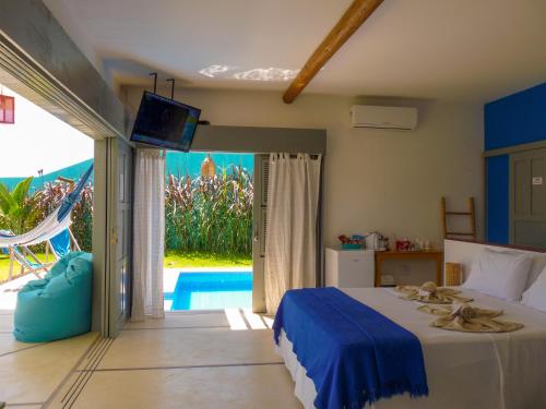 a bedroom with a bed and a view of a pool at Pousada Recanto Beija-Flor Kitesurf in Fortim