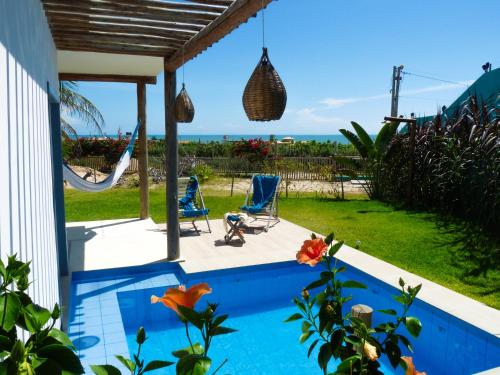 une maison avec une piscine dotée de 2 chaises et d'un hamac dans l'établissement Pousada Recanto Beija-Flor Kitesurf, à Fortim