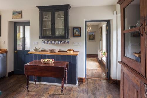 a kitchen with blue cabinets and a table at The Stable Yard House at Burtown House & Gardens in Athy