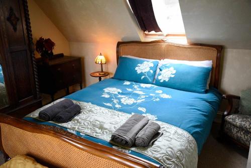 a bedroom with a blue bed with towels on it at Quaraing House in Staffin
