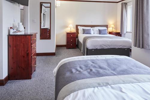 A bed or beds in a room at The Appleby Inn Hotel