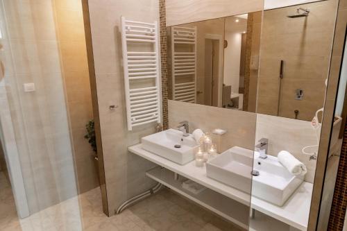a bathroom with two sinks and a mirror at Princ Apartment in Niš