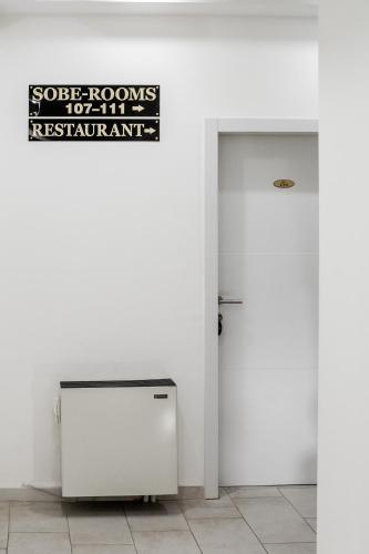 a white room with a door and a sign on the wall at Princ Apartment in Niš