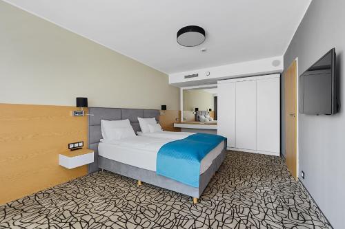 מיטה או מיטות בחדר ב-Aparthotel Termy Uniejów