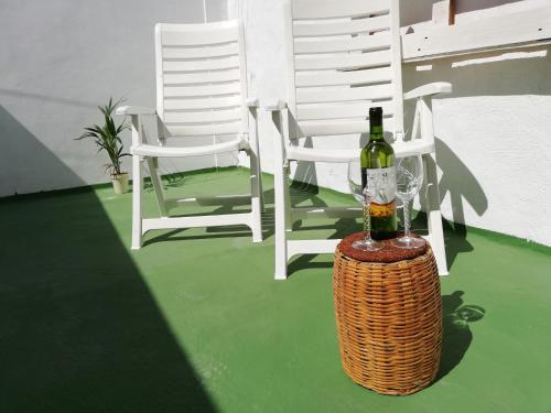 a bottle of wine sitting on a table next to two chairs at Apartment with terrace in Vecindario