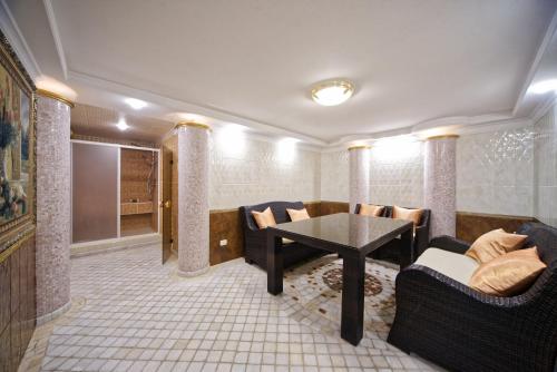 a living room with couches and a table and chairs at Villa Le Premier - Maestro in Odesa