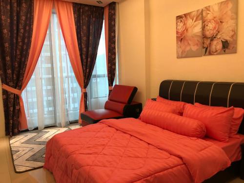 a bedroom with a red bed and a chair at KJ Homestay Casa Kayangan in Ipoh