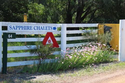 a white fence with a sign that reads sapphire charters at Sapphire Chalets, Augusta in Augusta
