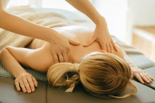 a woman getting a back massage from a therapist at Aparthotel Termy Uniejów in Uniejow
