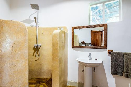 a bathroom with a sink and a mirror at Pongwe Beach Hotel in Pongwe