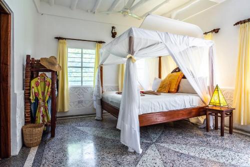 a bedroom with a bed with a canopy at Pongwe Beach Hotel in Pongwe