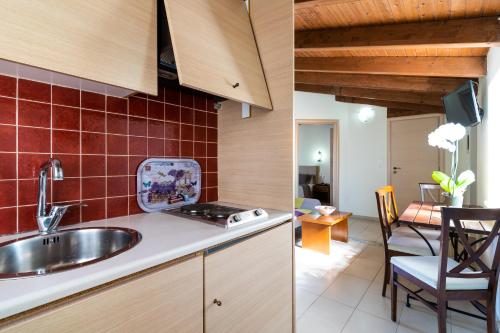 duas imagens de uma cozinha com um lavatório e uma sala de jantar em Villas Duc - Rhodes em Ialyssos