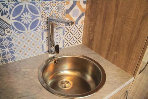 um lavatório de cozinha com uma torneira no balcão em Esra Hotel Apartment em Khasab