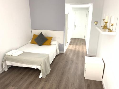 Habitación blanca con cama y espejo en Triana Luxury Apartament 329, en Sevilla