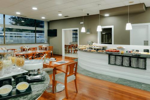 a restaurant with a counter and tables with food at Hesperia Vigo in Vigo