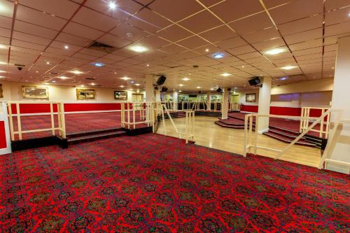 a room with a red carpet and a red rug at Britannia Hotel Wigan in Standish