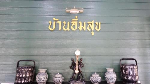 a group of vases on a shelf in front of a wall at Baan Imm Sook Resort in Chao Lao Beach