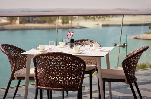 a white table and chairs with a view of the water at Grand Hyatt Abu Dhabi Hotel & Residences Emirates Pearl in Abu Dhabi