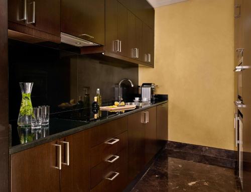 a kitchen with wooden cabinets and black counter tops at Grand Hyatt Abu Dhabi Hotel & Residences Emirates Pearl in Abu Dhabi