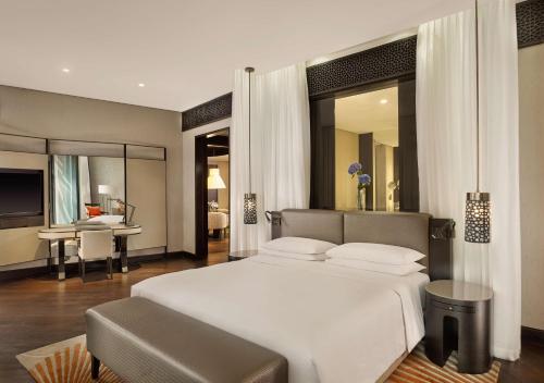 a bedroom with a large white bed and a desk at Grand Hyatt Abu Dhabi Hotel & Residences Emirates Pearl in Abu Dhabi