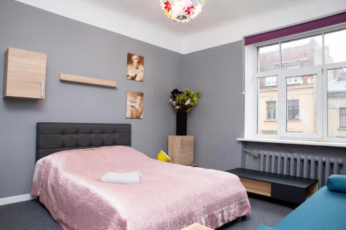 um quarto com uma cama rosa e uma janela em Urban Apartment em Riga