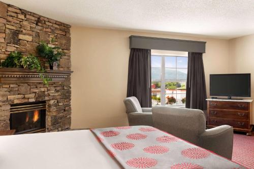 a living room with a fireplace and a television at Ramada by Wyndham Pigeon Forge North in Pigeon Forge