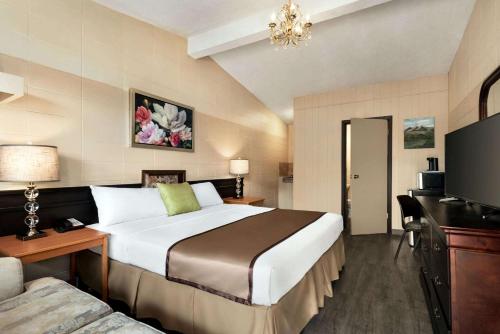 a hotel room with a large bed and a couch at Thriftlodge Edmonton in Edmonton