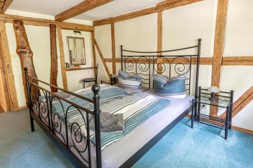 a bedroom with a black bed in a room at Altstadt-Pension Koch in Goslar