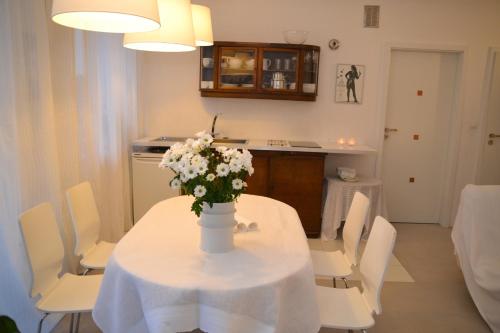 a white table with a vase of flowers on it at Apartament Przystań w Ustce - 120 m2 - 200 m od plaży Mickiewicza 2 in Ustka