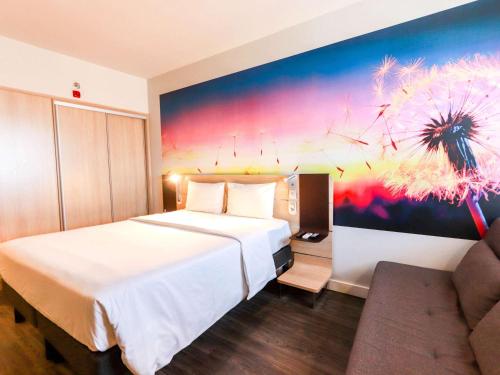 um quarto de hotel com uma cama grande e um sofá em Novotel Itajai em Itajaí