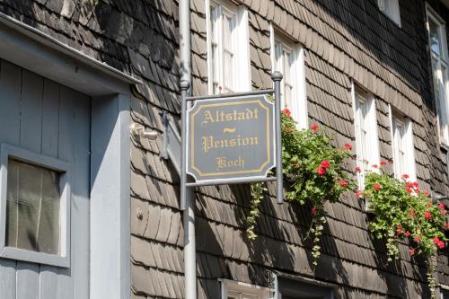 a sign on the side of a building with flowers at Altstadt-Pension Koch in Goslar