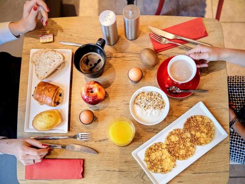 a wooden table with breakfast foods and coffee on it at ibis Lyon Gerland Musée des Confluences in Lyon