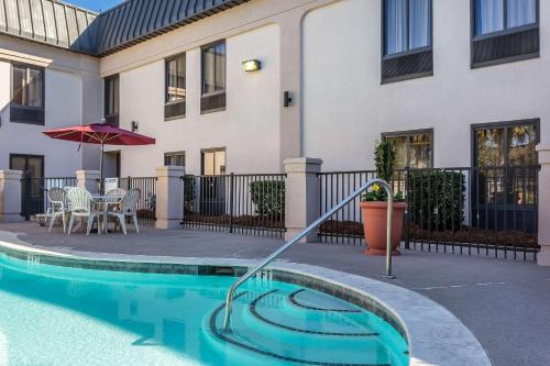 a house with a swimming pool in front of a building at Quality Inn Summerville-Charleston in Summerville