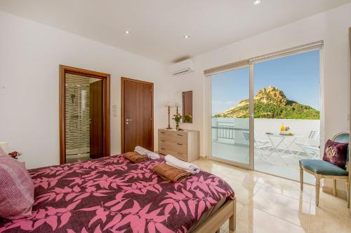 a bedroom with a bed and a view of the ocean at Hillock Residence Apartments in Marsalforn